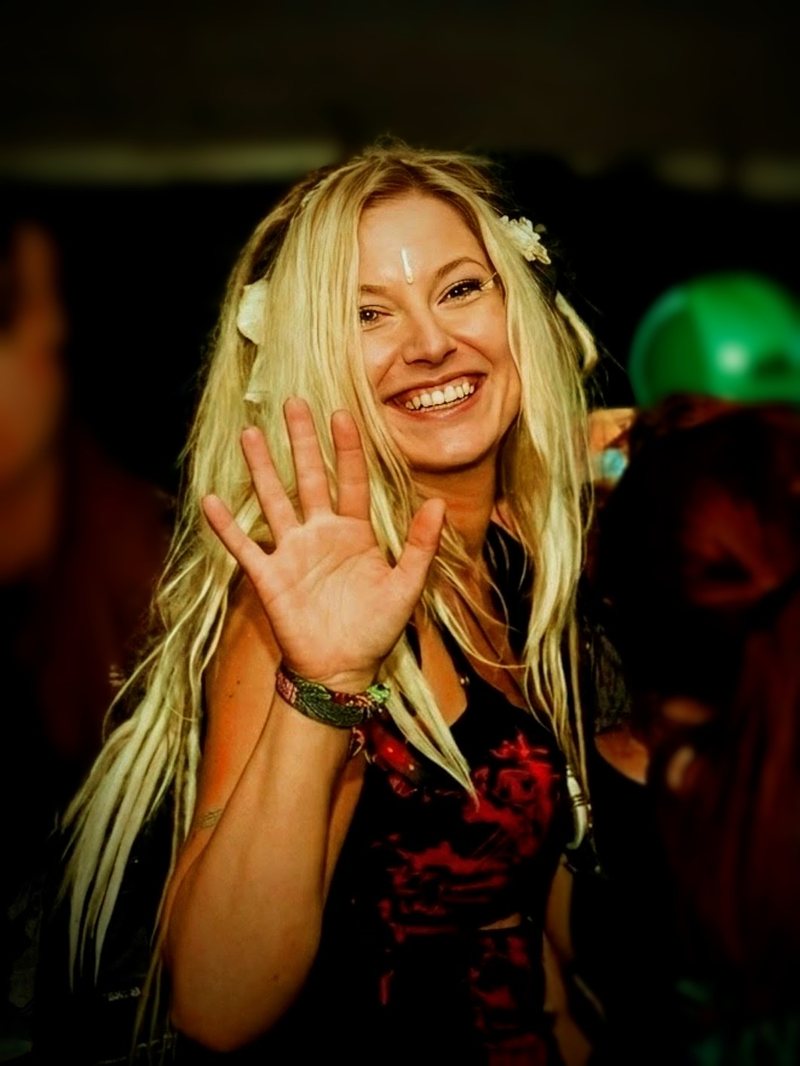 Djane Anastazja smiling and waving at the camera, flowers in her hair